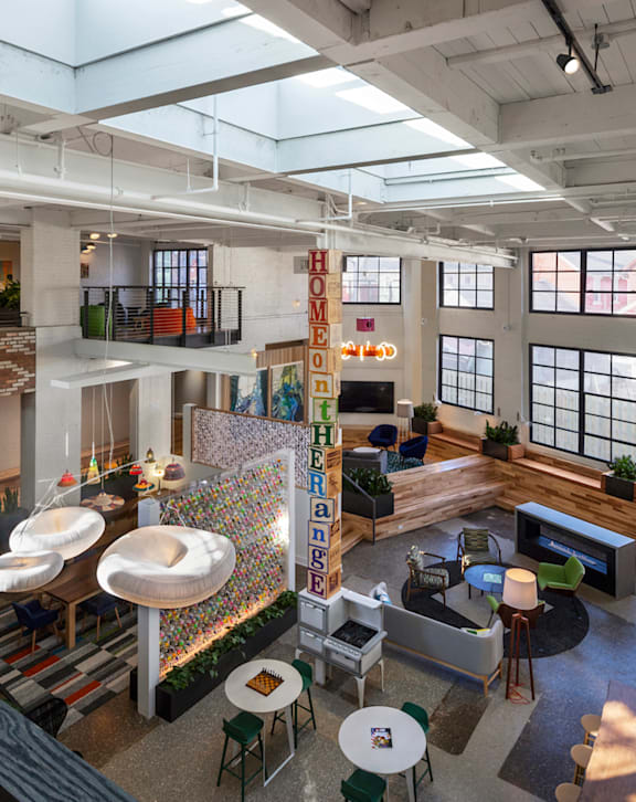 A modern office space with a variety of seating options and a skylight.