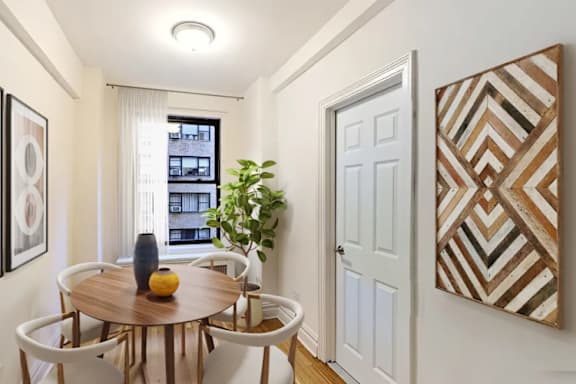 A dining room with a wooden table and chairs.at Sutton Collection, New York