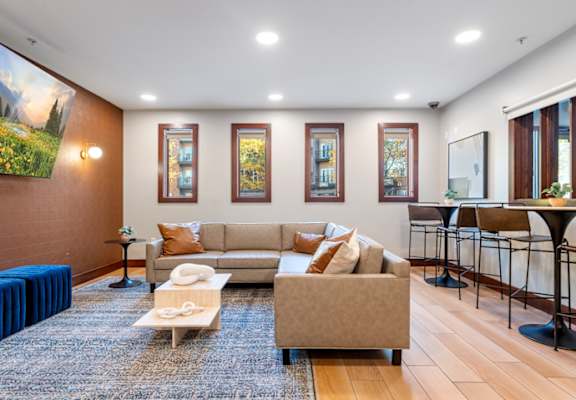 A living room with a stone fireplace and a large painting above it.