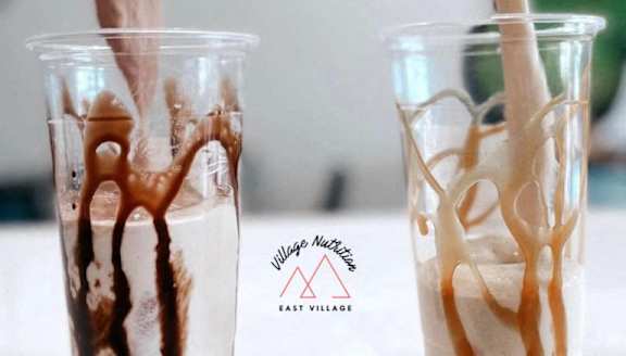 Two cups of milk tea with a straw in them.