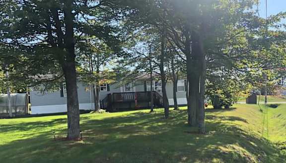 A white house is surrounded by trees.