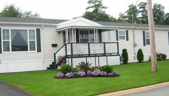 A white house with a black and white porch.