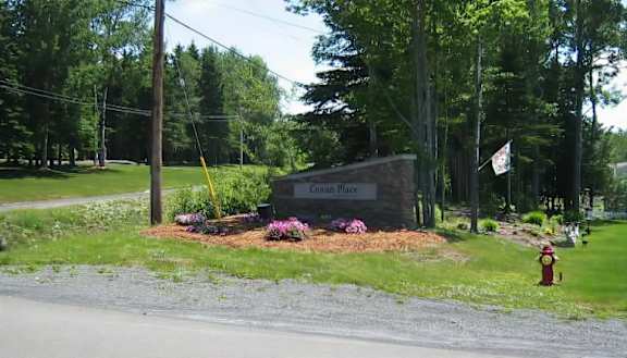 A sign that says "Cowan Place" is in front of a building and a fire hydrant.