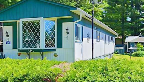A white and green house with a blue roof.