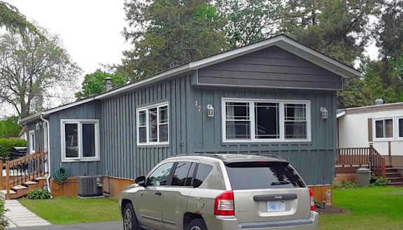 A house with a grey car parked in front.