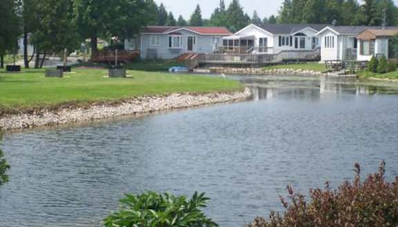 A body of water with a house in the background.
