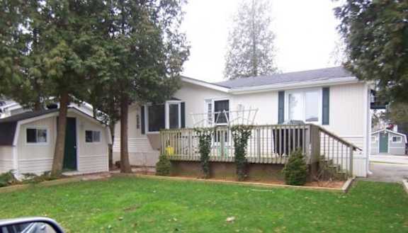 A white house with a green door and a small porch.
