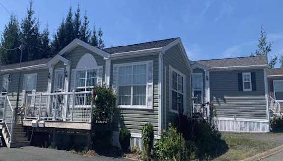 A row of mobile homes with a clear blue sky above.