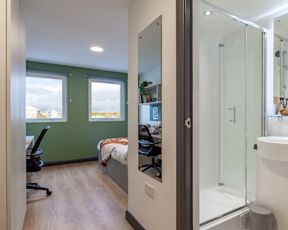 a bathroom with a shower and a sink and a bed