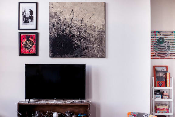 a living room with a television and pictures on the wall