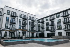 an apartment building with a pool in front of it