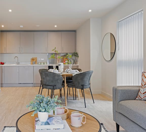 A modern dining room with a round mirror on the wall.