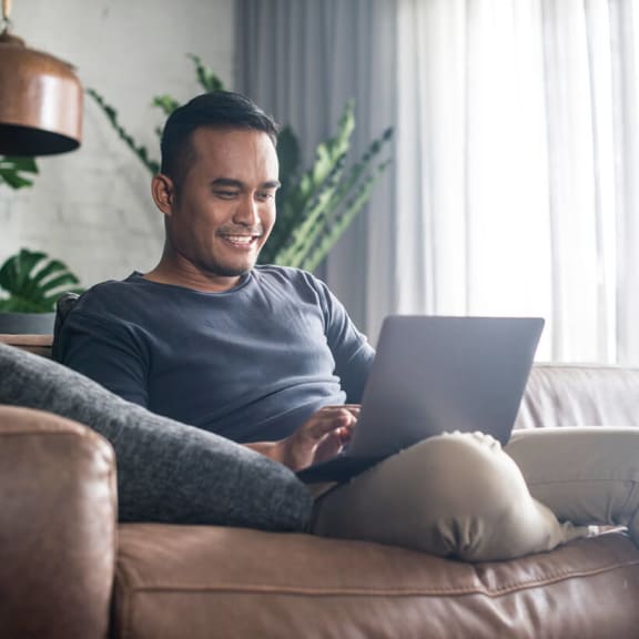 Person using laptop sitting on couch