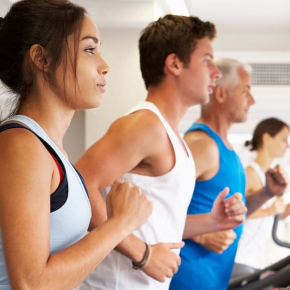 Group of people running on treadmill