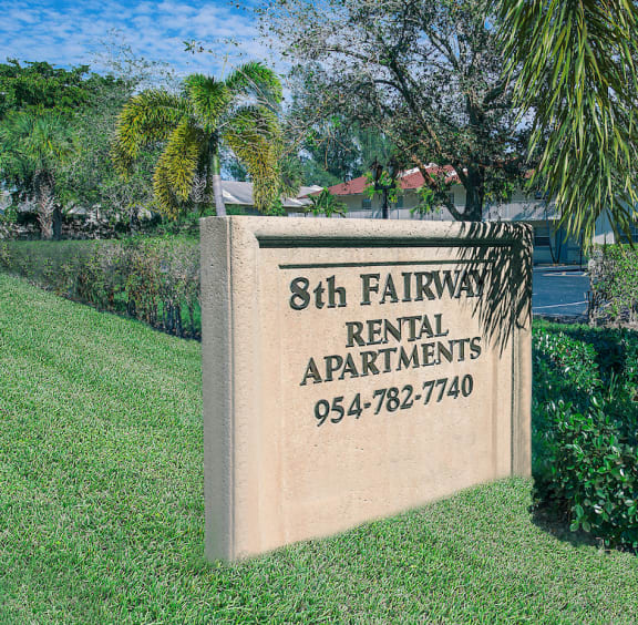 a sign for 8th fairway rental apartments in front of a palm tree
