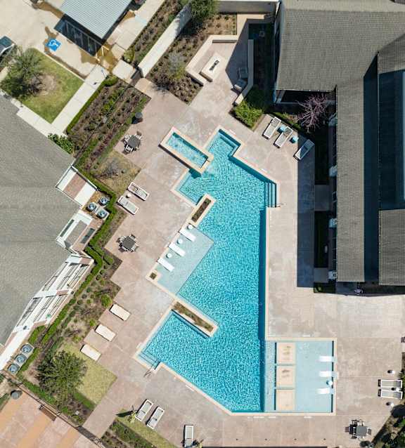 An aerial view of a swimming pool surrounded by buildings.