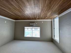 an empty room with a window and a wood ceiling  at Palm Gardens @ Biscayne Gardens, North Miami, FL