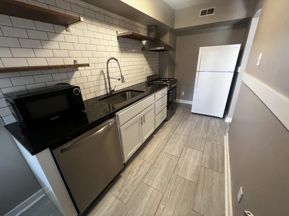 a view of the kitchen from the corner of the room with a sink and a