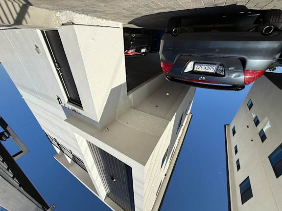 A car is parked under a bridge with a license plate that reads "928-XEIH".