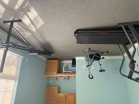 A room with a treadmill and a television.