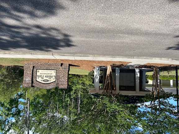 a reflection of a house with a sign in the water