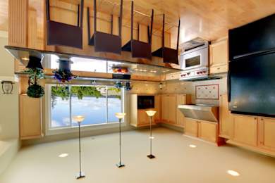 a kitchen with wooden cabinetry and a large center island with a black countertop