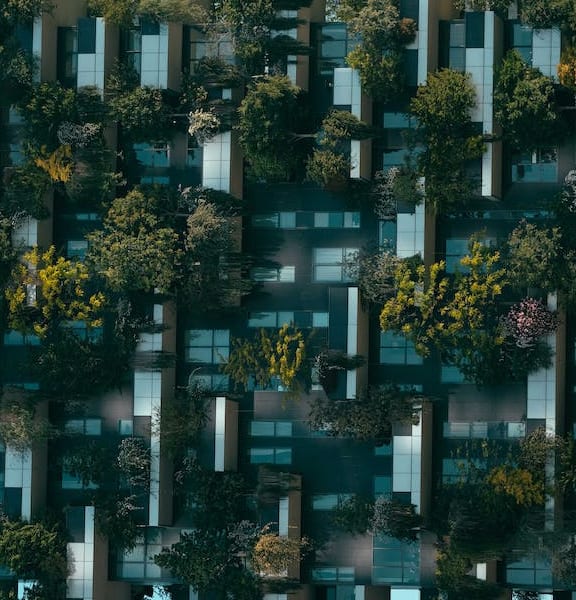 a picture of an apartment building with green plants on the balconies