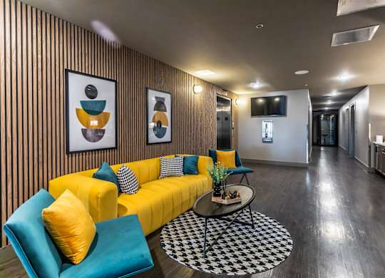 a living room with a yellow couch and blue chairs