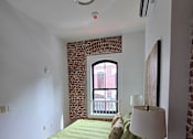 Thumbnail 17 of 22 - a bedroom with a bed and a window in a small room