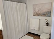 Thumbnail 19 of 22 - a small bathroom with a bed and a wooden floor