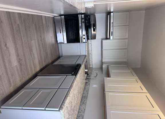 A modern kitchen with a stainless steel refrigerator and a white countertop.