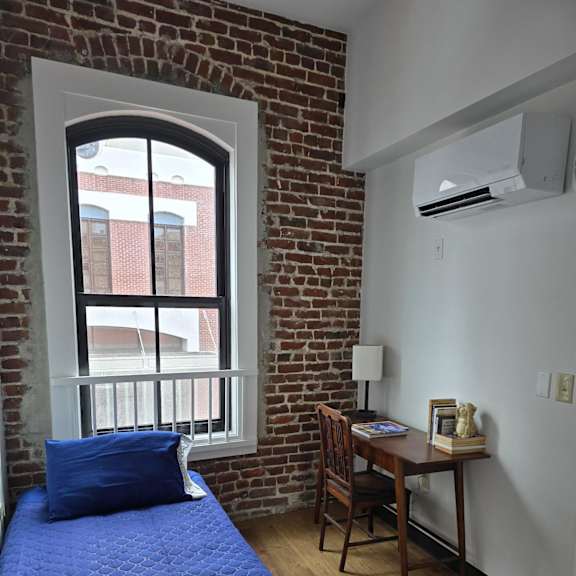 a bedroom with a window and a bed with a blue blanket