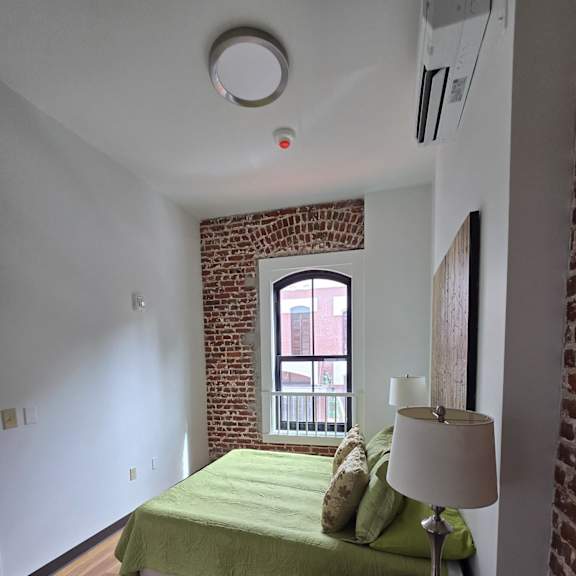 a bedroom with a bed and a window in a small room