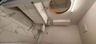 A bathroom with a toilet, sink, and mirror.