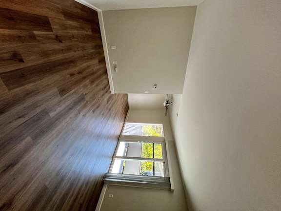 A wooden staircase with a skylight above it.
