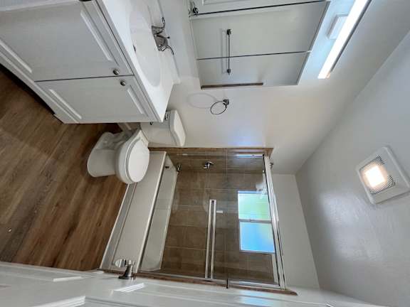 A modern bathroom with a walk-in shower and a toilet.