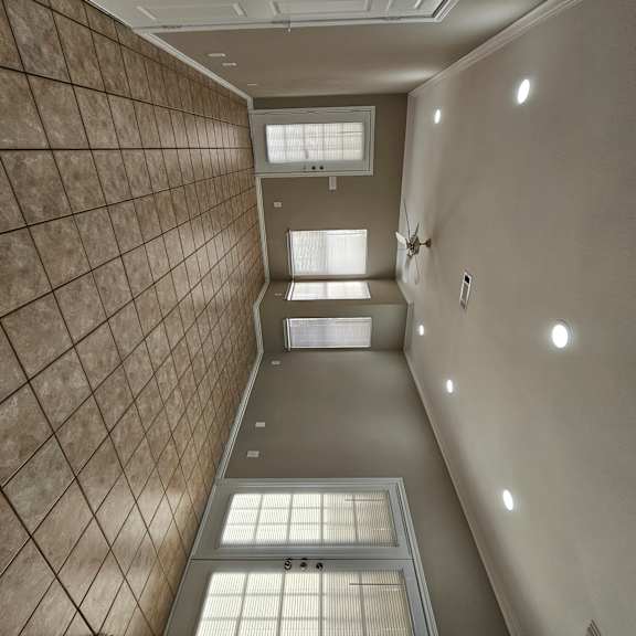 A hallway with a tiled wall and a skylight.