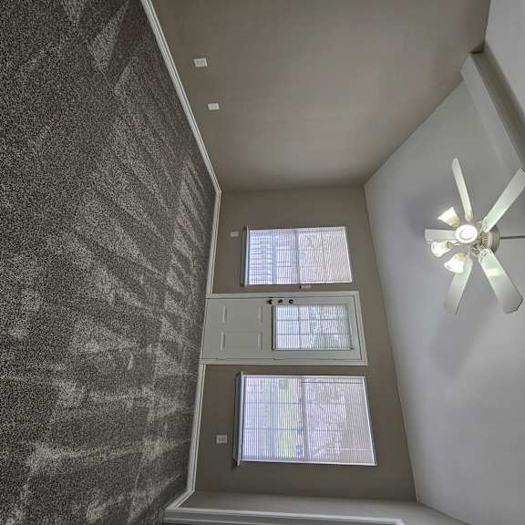 A room with a ceiling fan and a window.