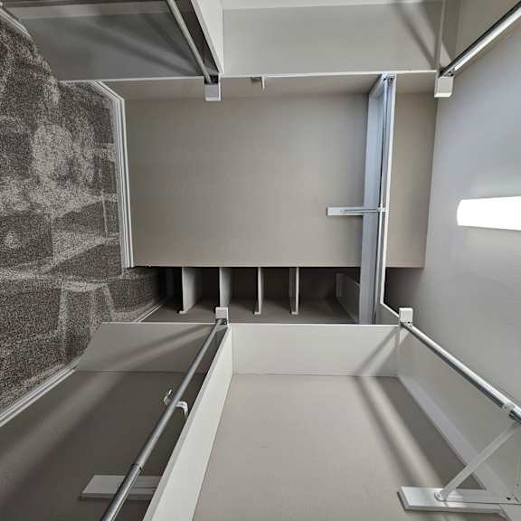 A white room with a staircase and a wall with a pattern on it.