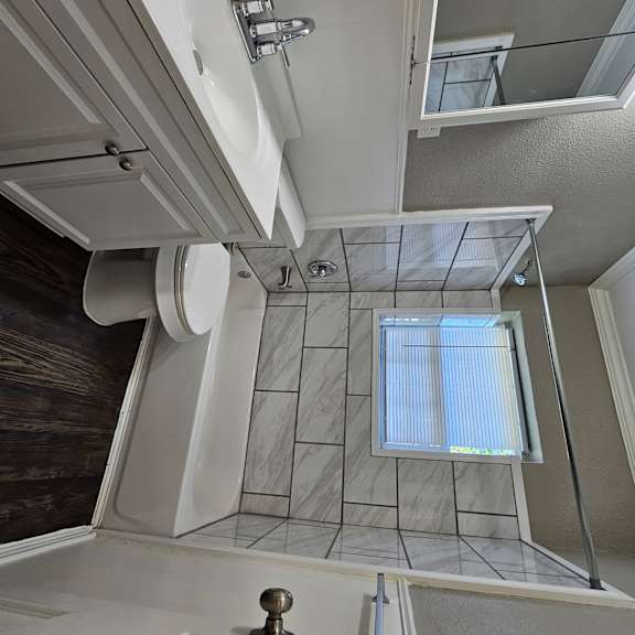 A bathroom with a toilet, sink, and shower.