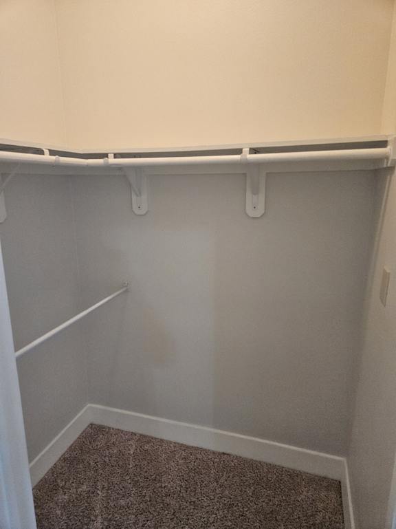 A white refrigerator with a brown carpet on the right side.