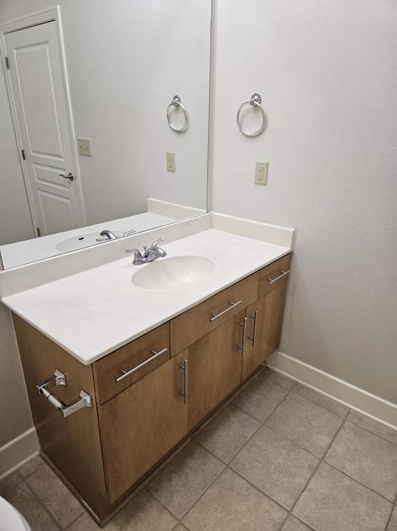 A white sink is installed in a wooden cabinet.