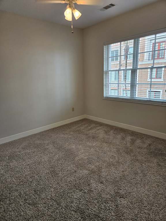 A room with a ceiling fan and a window.