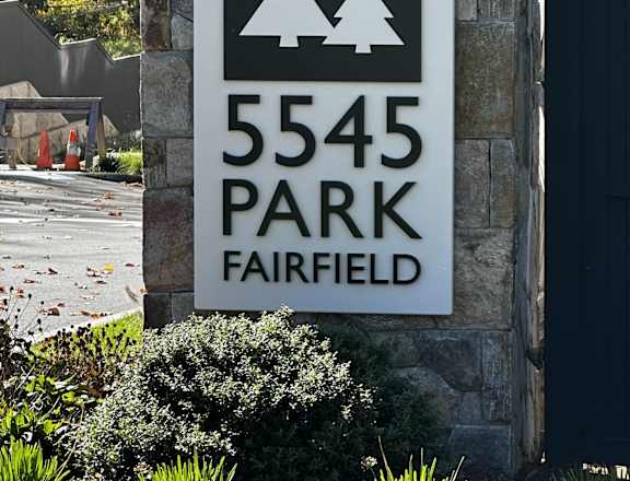 A sign for 5545 Park Fairfield is displayed on a stone wall.