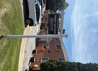 A car is parked in front of a building with a sign that says