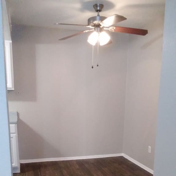 a view of the living room with a wood accent wall and a ceiling fan