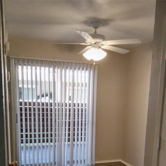 a window with white blinds and a clock on the wall