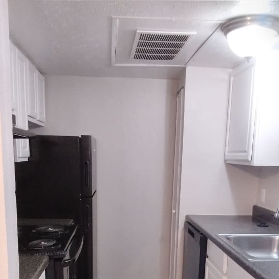 a kitchen with a stove and a microwave in a small room