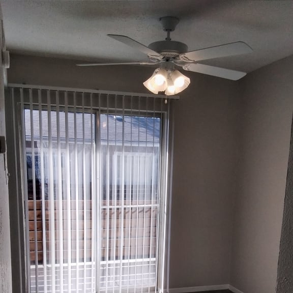 a view of a window with blinds and a ceiling fan