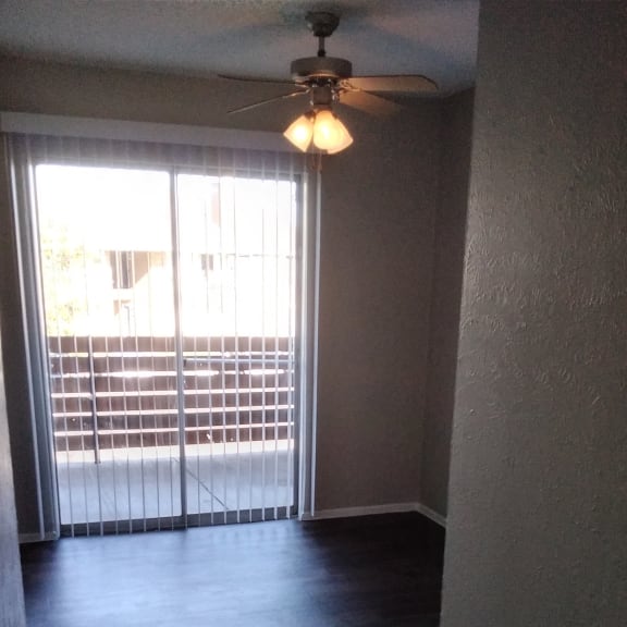 an empty room with a window and a light on the wall